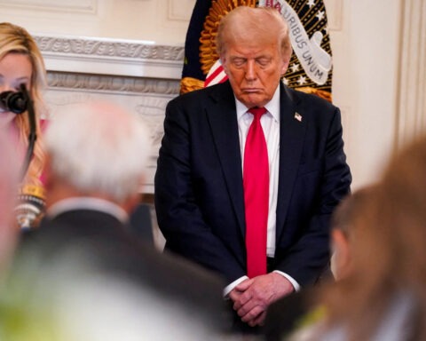 Donald Trump standing with eyes closed at White House prayer luncheon