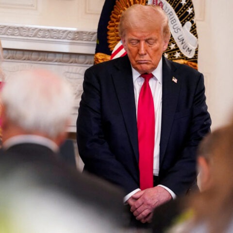 Donald Trump standing with eyes closed at White House prayer luncheon