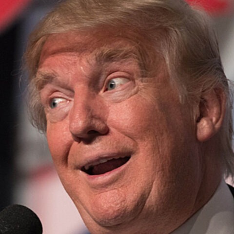 Donald Trump making a dumb facial expression at a microphone
