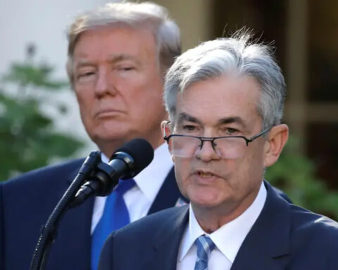 Donald Trump glares behind Jerome Powell during a press conference
