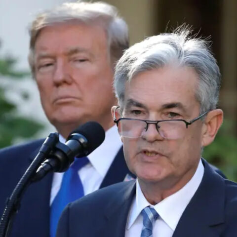 Donald Trump glares behind Jerome Powell during a press conference