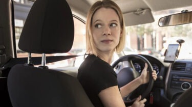 Female Uber driver looking back from driver’s seat