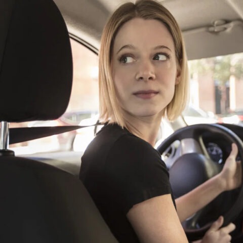 Female Uber driver looking back from driver’s seat
