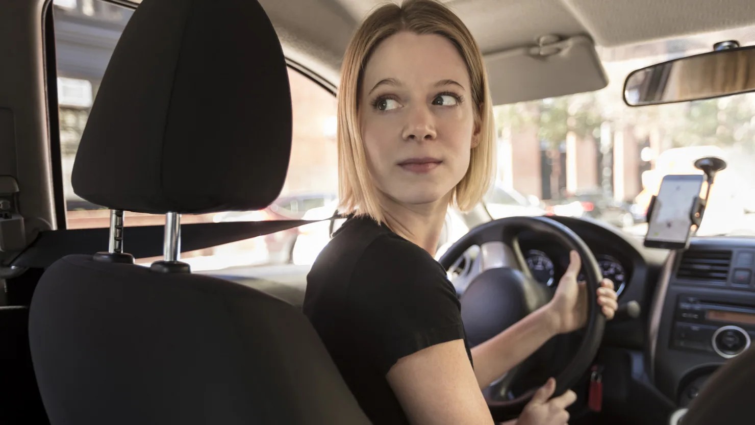 Female Uber driver looking back from driver’s seat