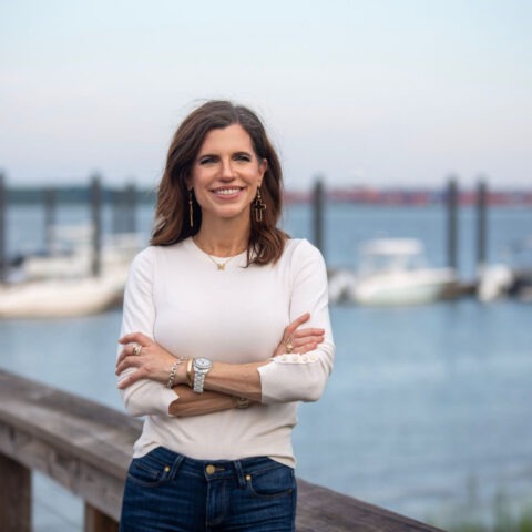 Nancy Mace stands near a dock smiling with arms crossed