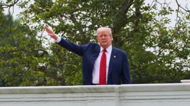 Donald Trump raising an arm from the roof of the White House