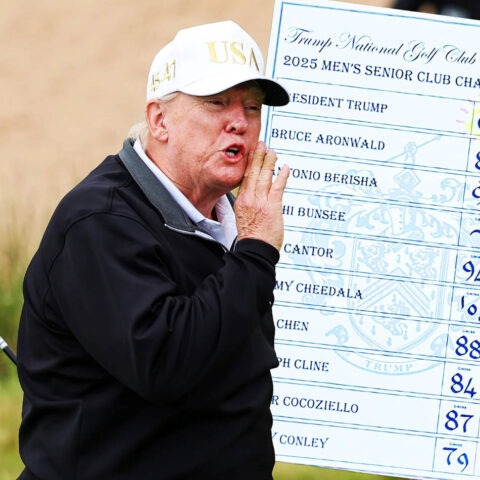 Trump holding golf club and scorecard at Bedminster championship