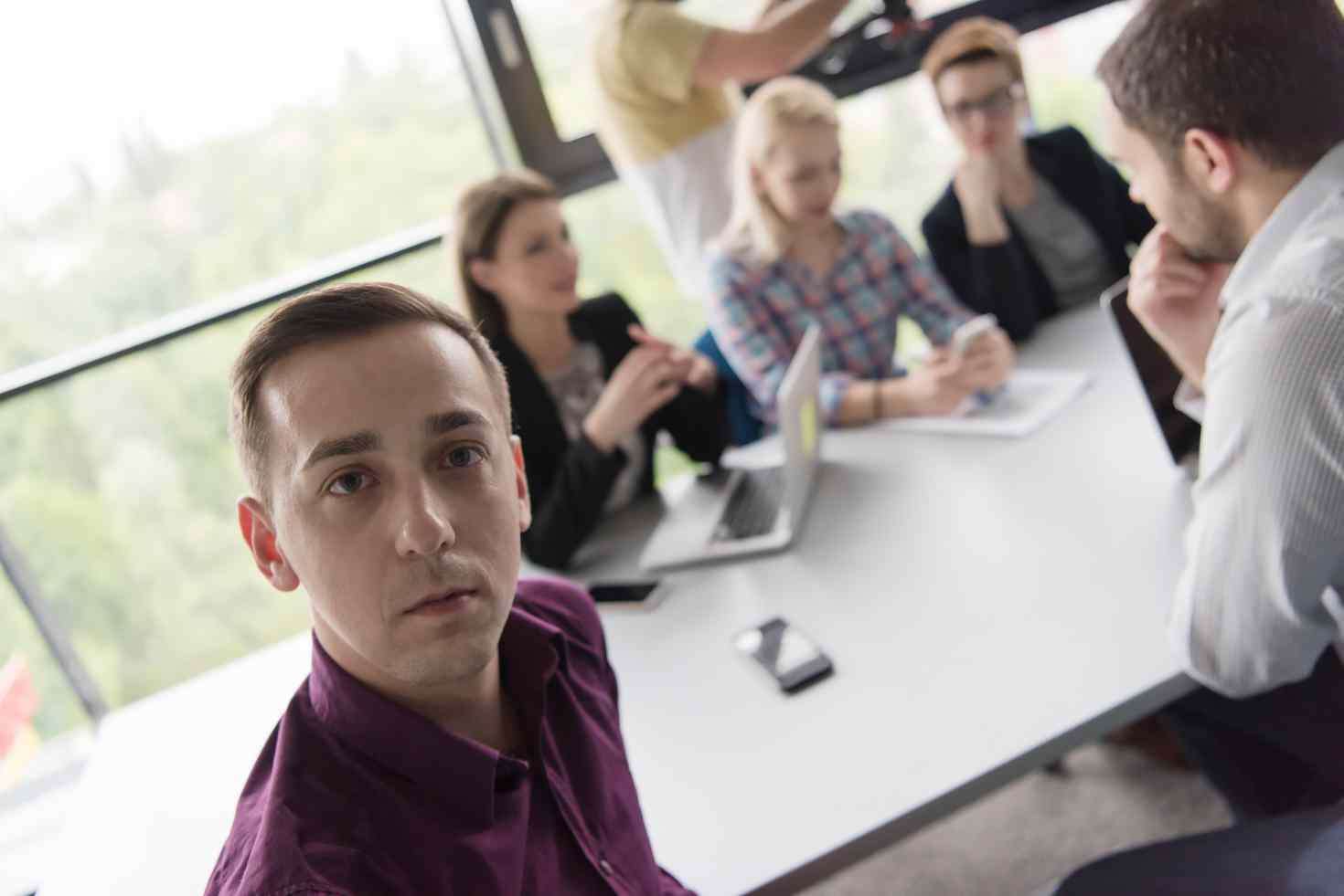 Group of young professionals gathered at a table for a meeting.