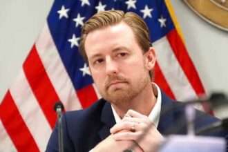 Oklahoma Superintendent Ryan Walters speaking in front of an American flag