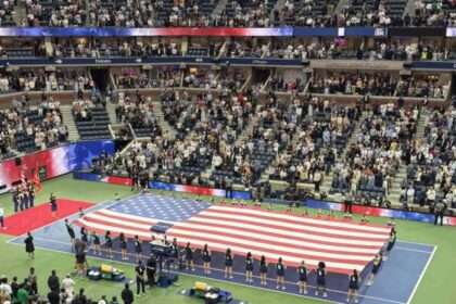 Large American flag displayed on the court at the U.S. Open before a match.