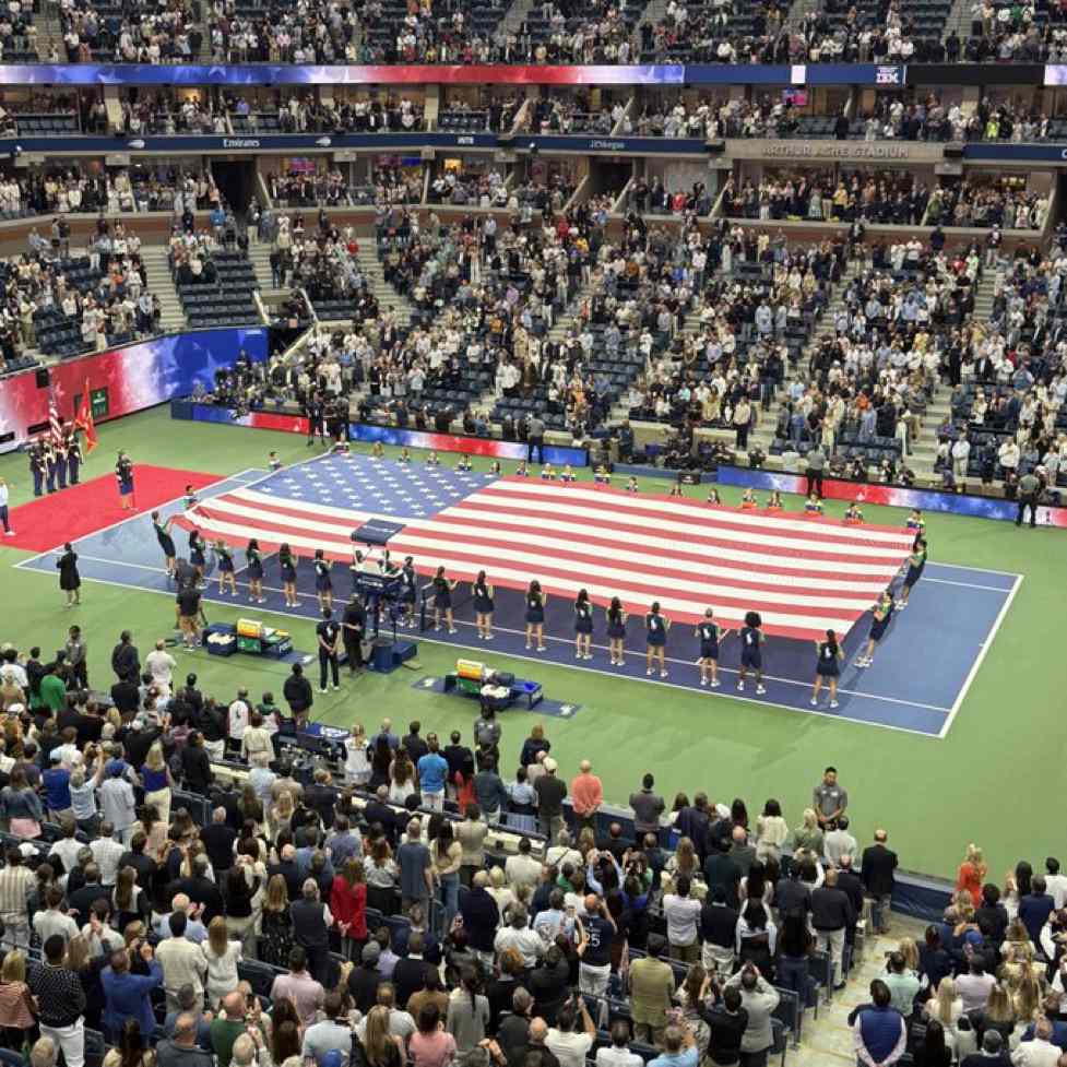Large American flag displayed on the court at the U.S. Open before a match.