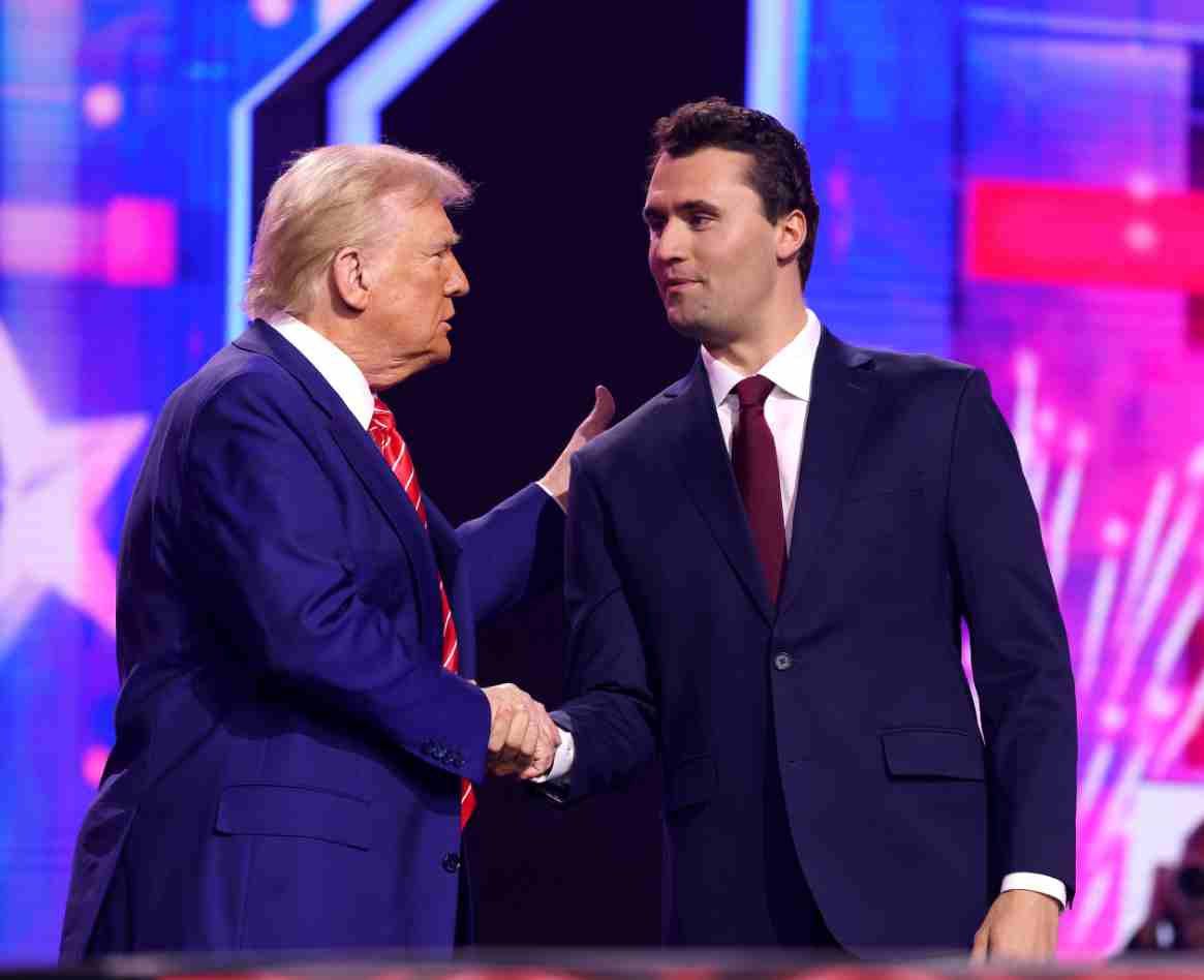 Donald Trump shaking hands with Charlie Kirk on stage