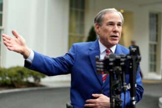 Texas Governor Greg Abbott speaks to reporters outside a building