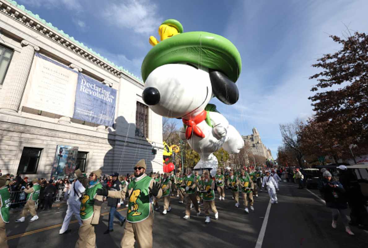 Parade staff guiding a large Snoopy balloon during the Macy’s Thanksgiving Day Parade.