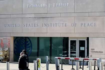 Trump stamps his name on peace while turning the building into a courtroom prop.